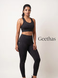 Model wearing black sleeveless gym crop top with matching high-rise leggings