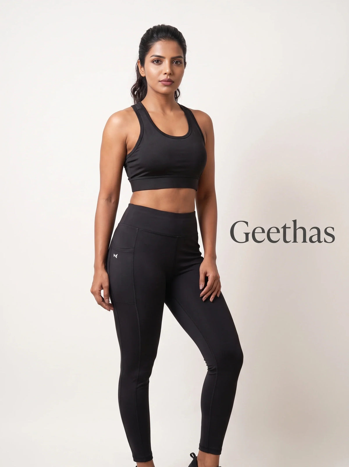 Model wearing black sleeveless gym crop top with matching high-rise leggings