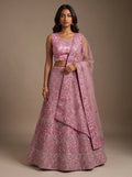 Model wearing dusty pink floral embroidered net lehenga set with matching bordered dupatta