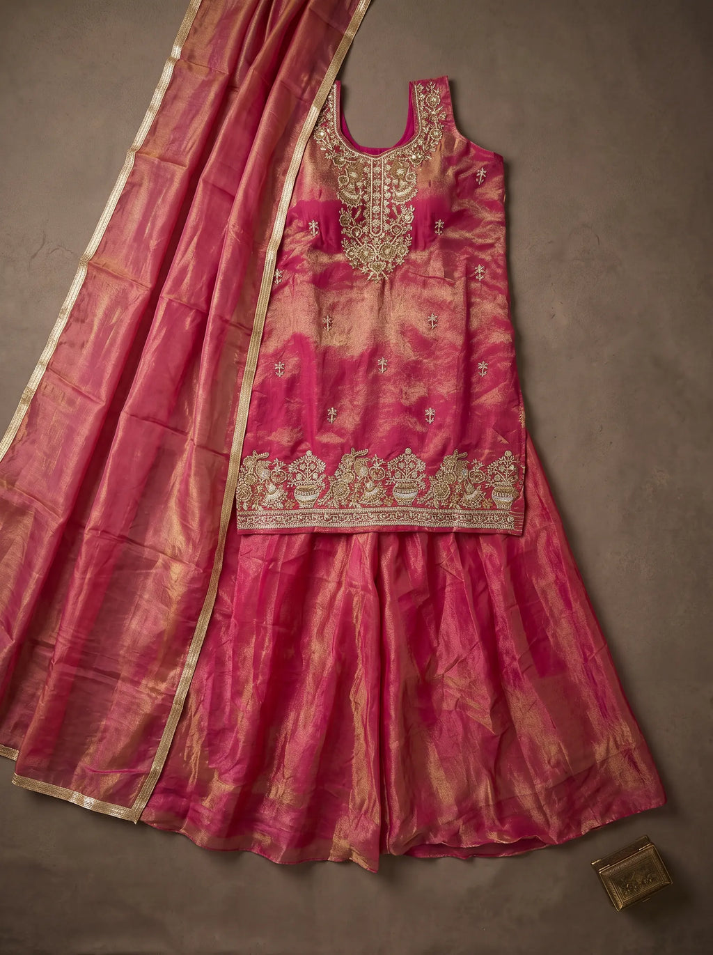 Fuchsia pink and metallic gold tissue silk sharara set with sequin and cut-bead embellished top, laid flat with matching dupatta