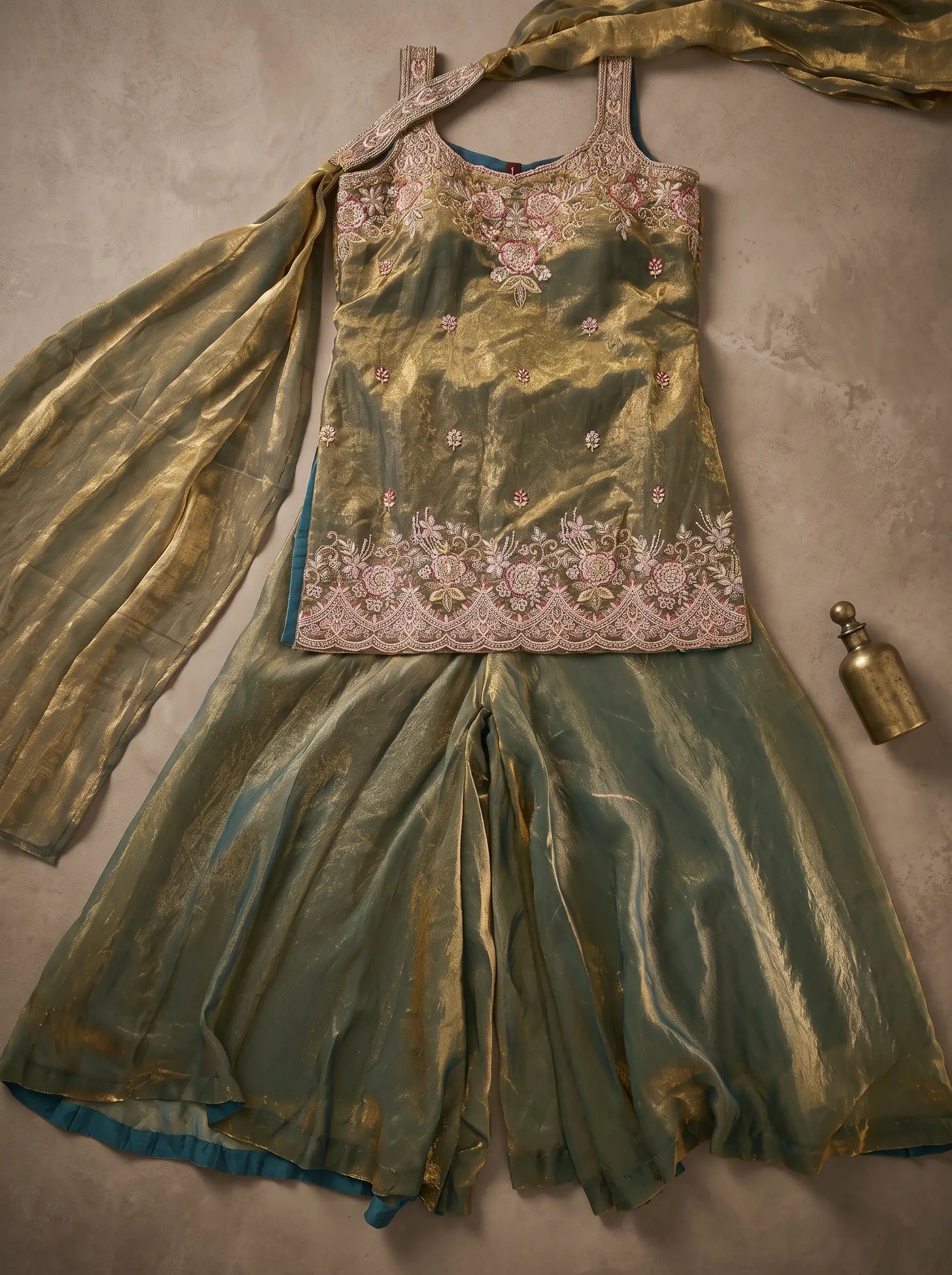 Olive green tissue silk sharara set flat lay showing floral embroidered top, flared sharara and matching dupatta