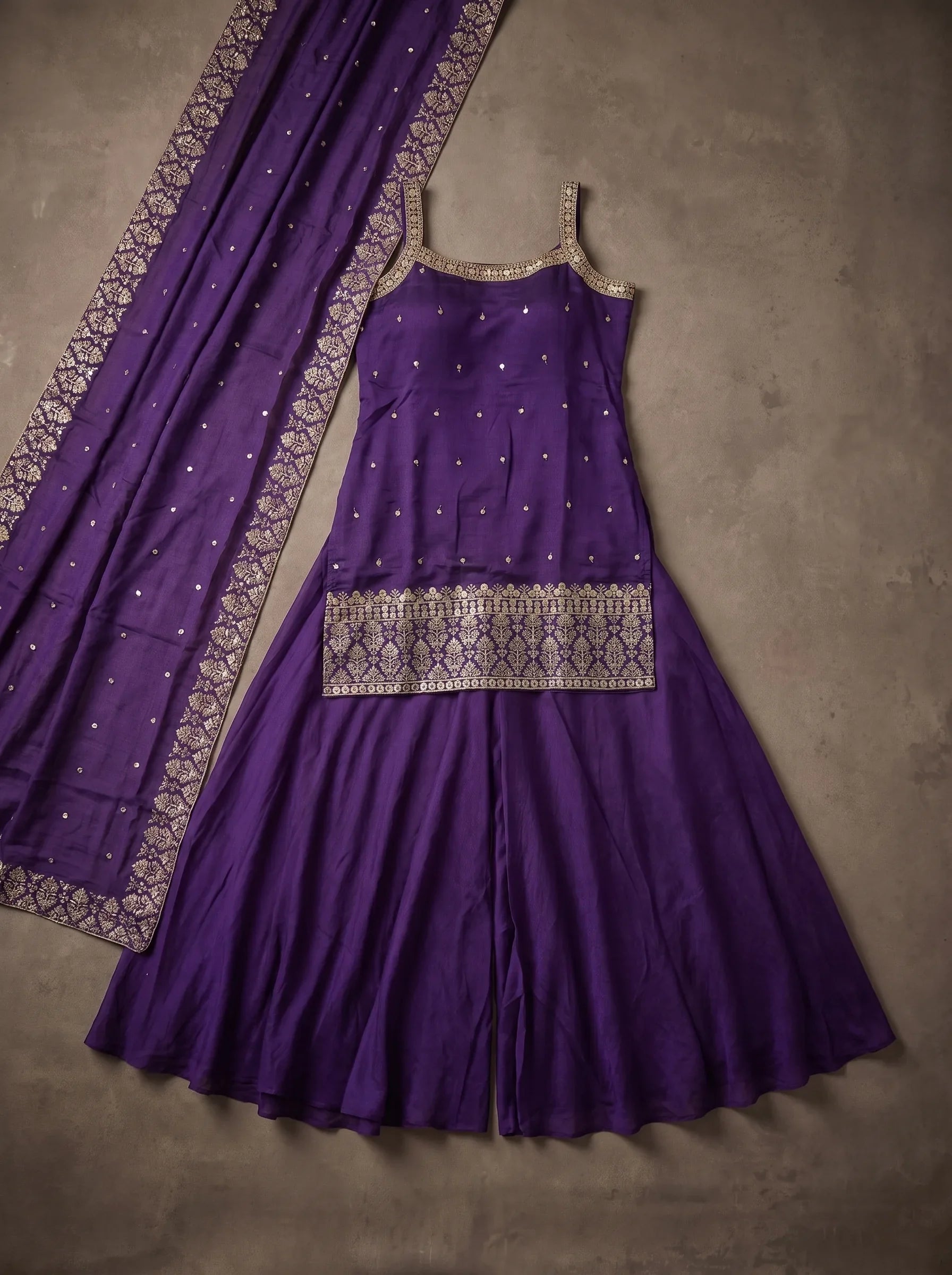 Flat lay of violet georgette sharara set with embroidered top, flared bottom and matching bordered dupatta